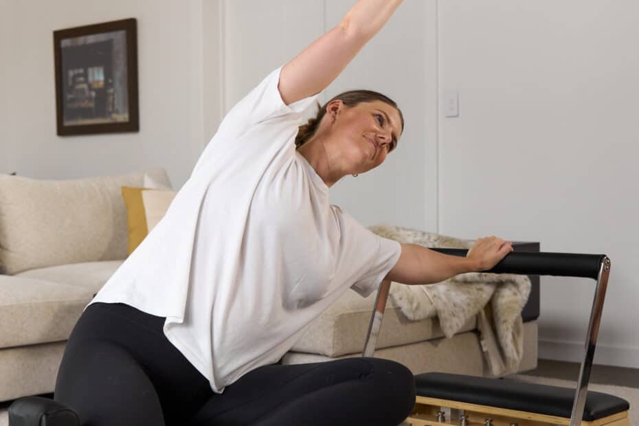 Woman stretching for low back pain on reformer