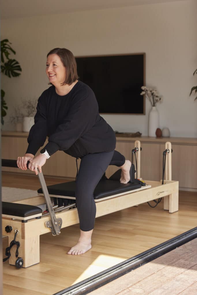 Middle-aged woman with arthritis exercising on reformer